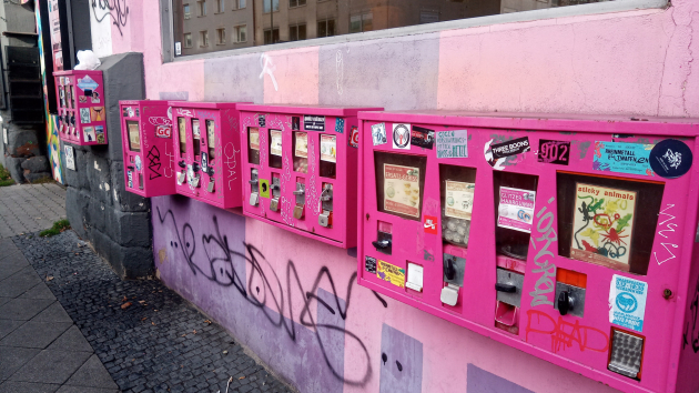 Eine Reihe pinkfarbener Automaten an einer rosafarbenen Hauswand
